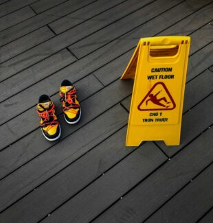 wet floor sign near pair of shoes